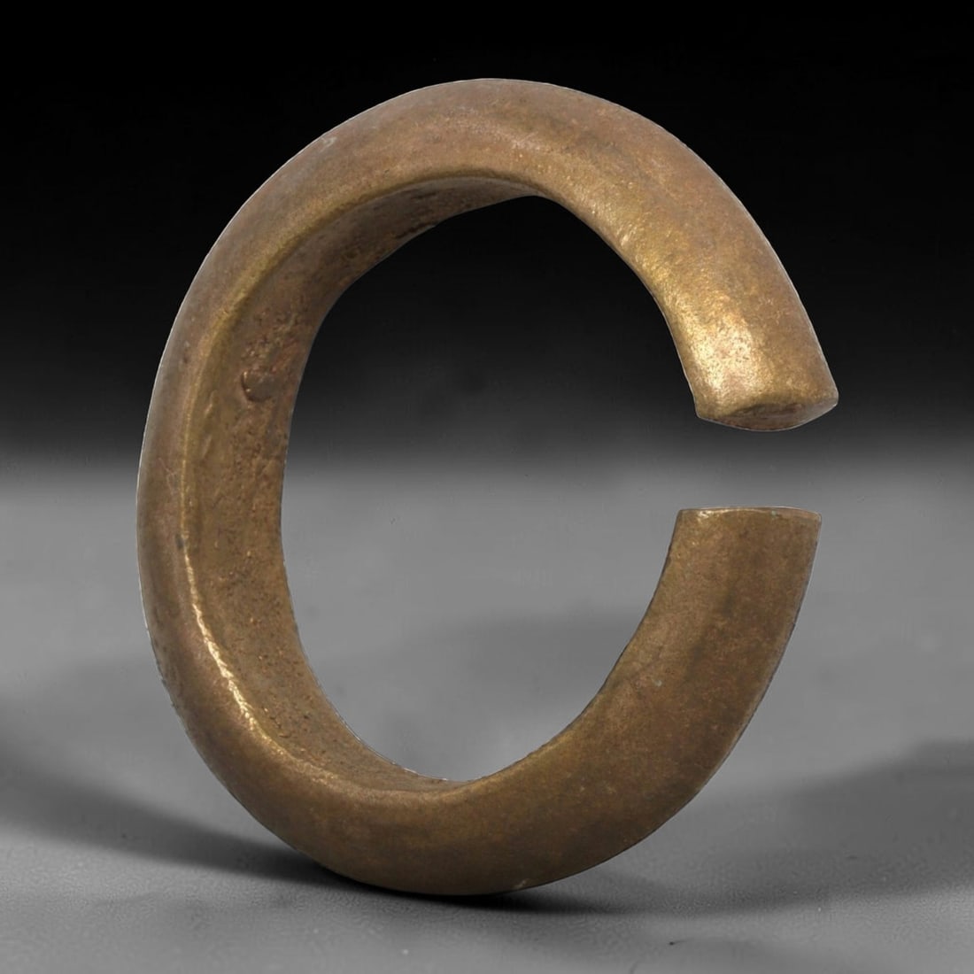 Ancient Roman Bronze Bracelet - Thick Open Cuff, 66BN, 66BN: Crafted from bronze, this open bracelet features a thick, robust C-shaped form with a narrow gap between flat, undecorated terminals. The surface retains a smooth, warm metallic patina with minimal ox