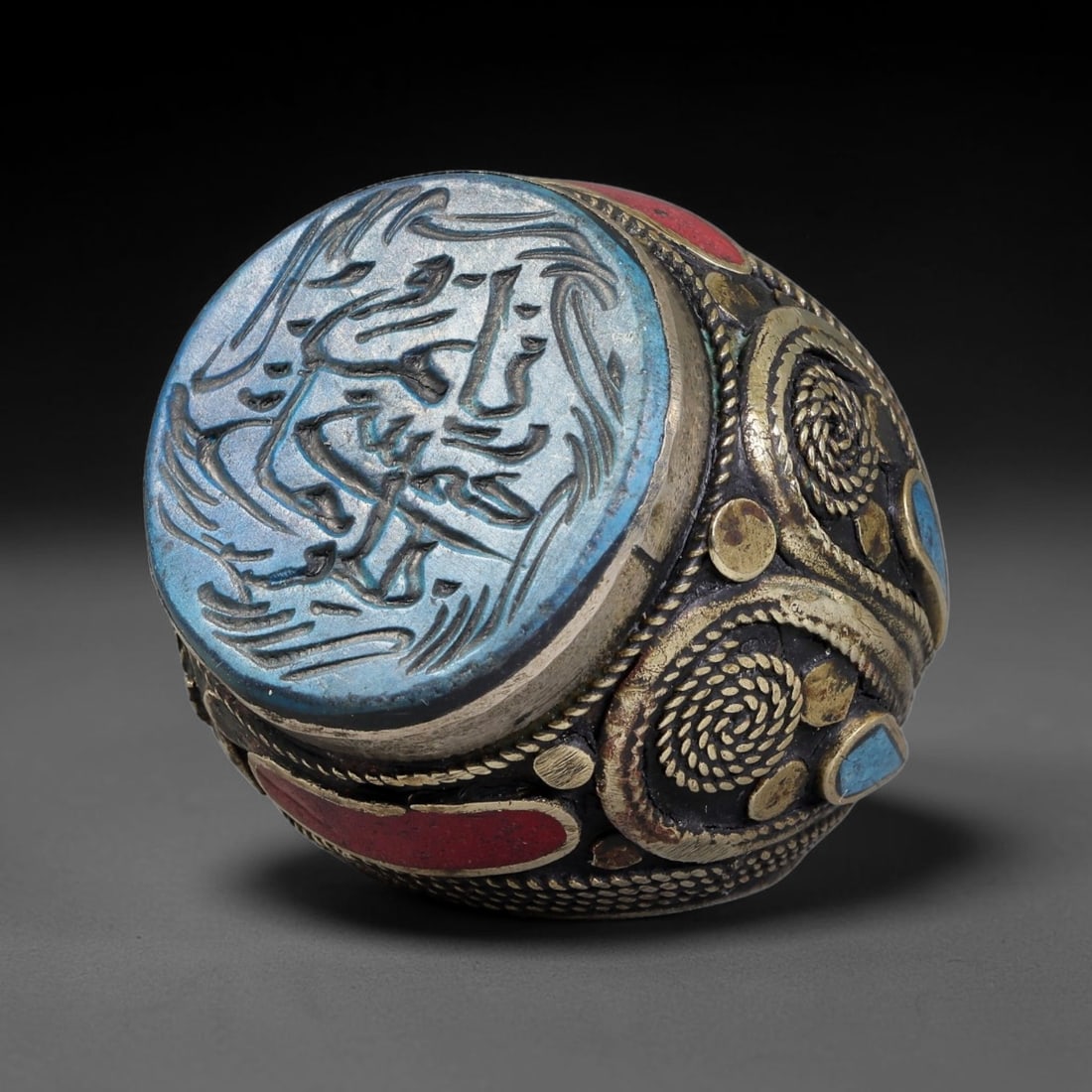 Vintage Islamic Handcrafted Silver Plated Calligraphic Talisman Statement Ring, 10BX: This vintage hand-wrought Islamic statement ring features a central engraved panel bearing traditional calligraphic detailing, set within an ornate silver-plated metal band. The mounting is enriched w