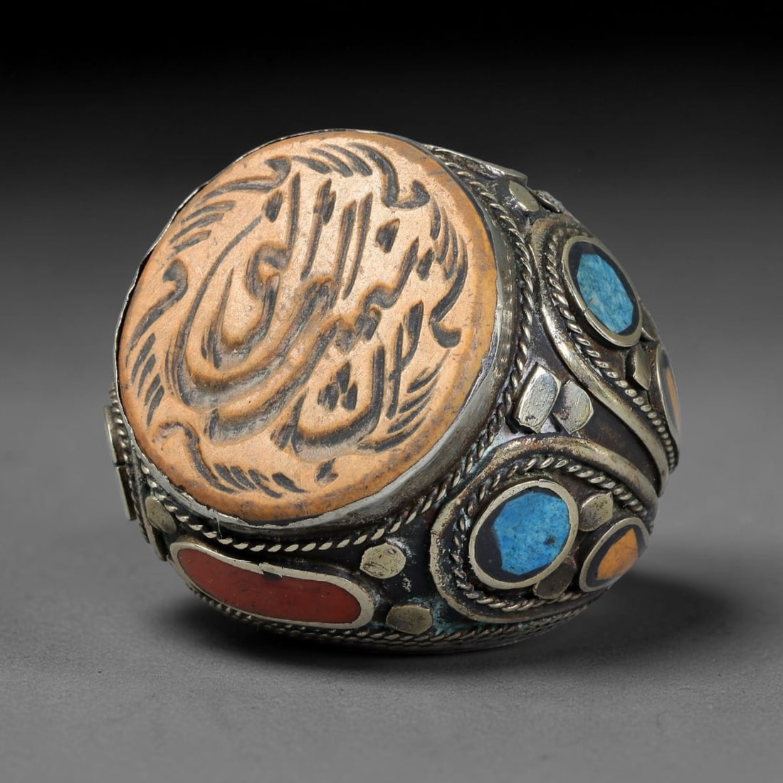 Vintage Islamic Handcrafted Silver Plated Calligraphic Talisman Statement Ring, 9BX: This vintage hand-wrought Islamic statement ring features a central engraved panel bearing traditional calligraphic detailing, set within an ornate silver-plated metal band. The mounting is enriched w
