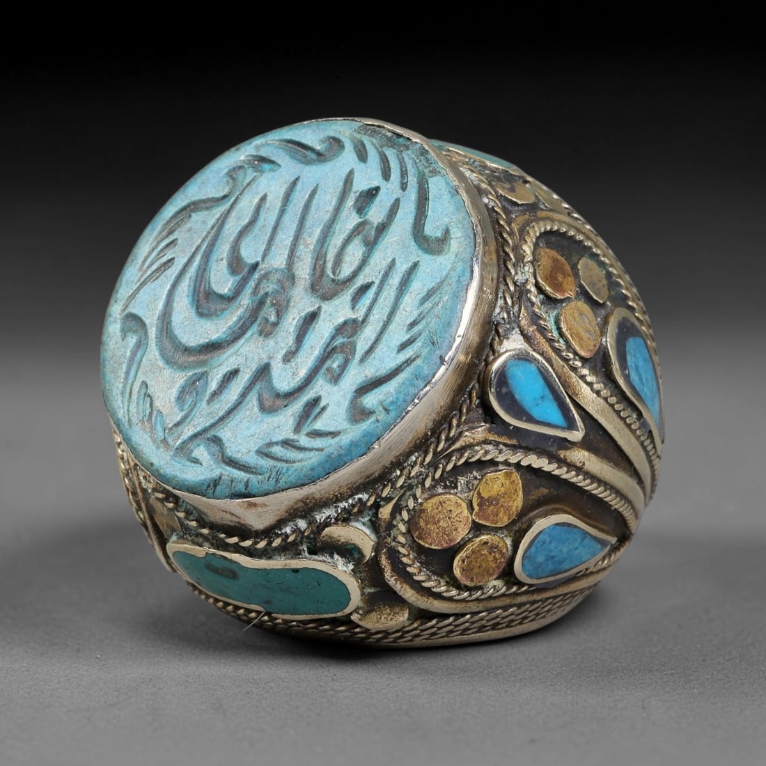 Vintage Islamic Handcrafted Silver Plated Calligraphic Talisman Statement Ring, 13BX: This vintage hand-wrought Islamic statement ring features a central engraved panel bearing traditional calligraphic detailing, set within an ornate silver-plated metal band. The mounting is enriched w