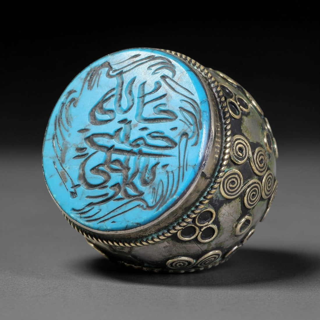 Vintage Islamic Handcrafted Silver Plated Calligraphic Talisman Statement Ring, 6BX: This vintage hand-wrought Islamic statement ring features a central engraved panel bearing traditional calligraphic detailing, set within an ornate silver-plated metal band. The mounting is enriched w