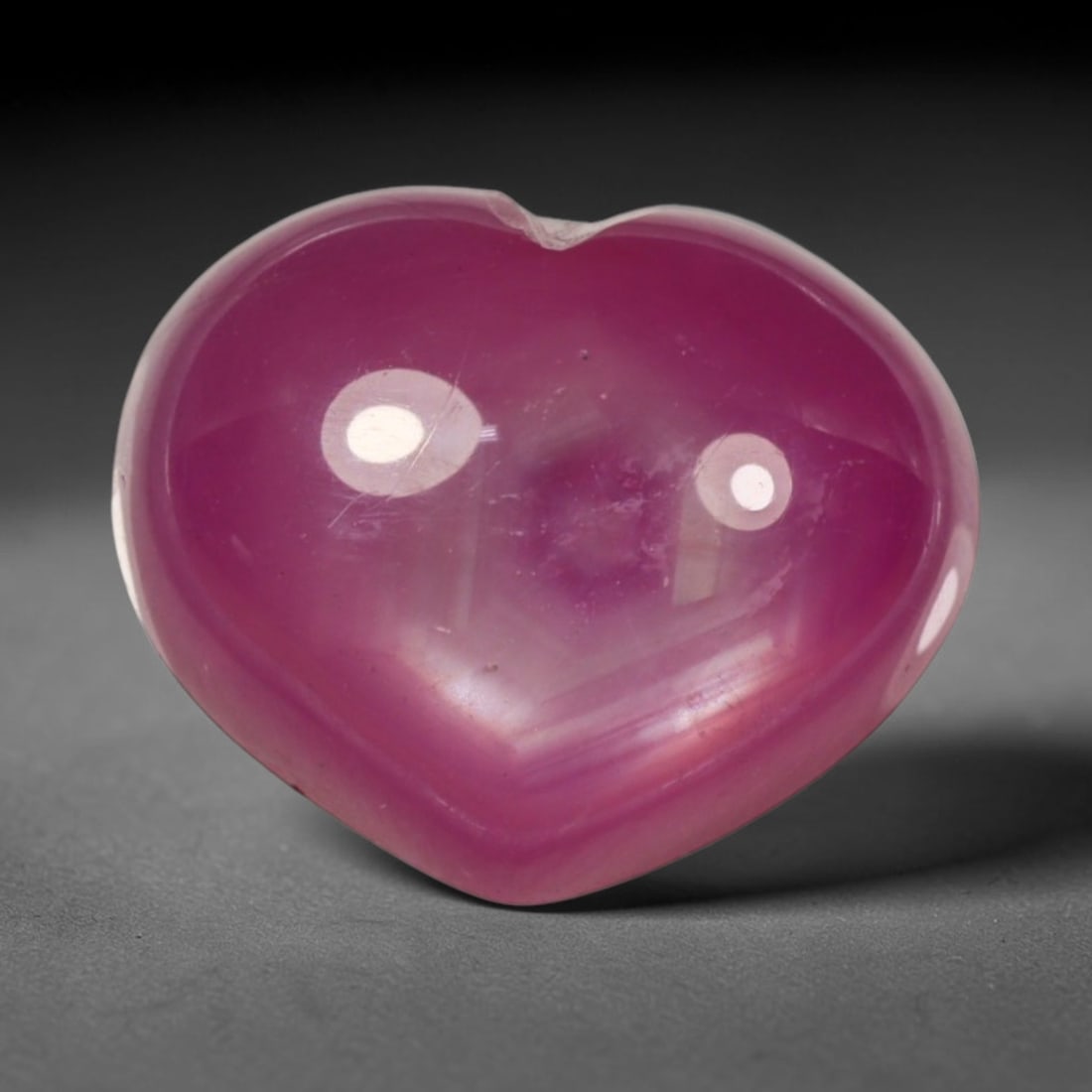 9.37ct Natural Mozambique Hot Pink Ruby Loose Gemstone, 70BP: This heart shaped Mozambique ruby cabochon measures 12.9x10.8x6.3mm, showcasing a vivid saturated hot pink body paired with stunning natural hexagonal crystal growth banding that forms a distinct geom