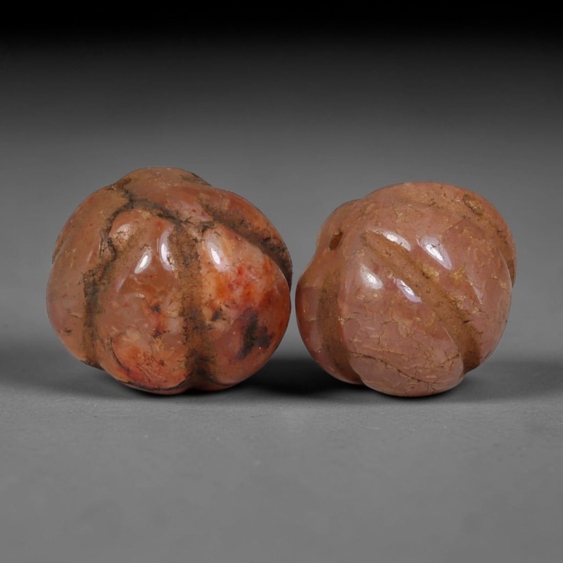 Ancient Medieval Khmer Angkor Culture Carved Carnelian Melon Bead Pair (802-1431 CE), 51AE: This matched pair of antique hand-carved melon form carnelian beads originates from Khmer Angkor Culture, the medieval Southeast Asian civilization renowned for crafting ritual chalcedony adornments f
