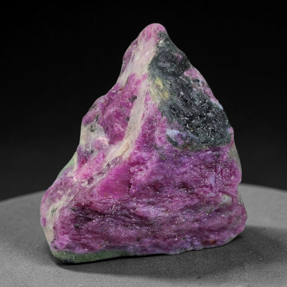 85ct Natural Tanzanian Ruby Zoisite Raw Rough Specimen Mineral Stone, 13FC: This unpolished mineral rough is natural ruby zoisite sourced from Tanzania, exhibiting distinct banded mineral segregation of vibrant green zoisite, magenta ruby crystals, and dark hornblende inclusi