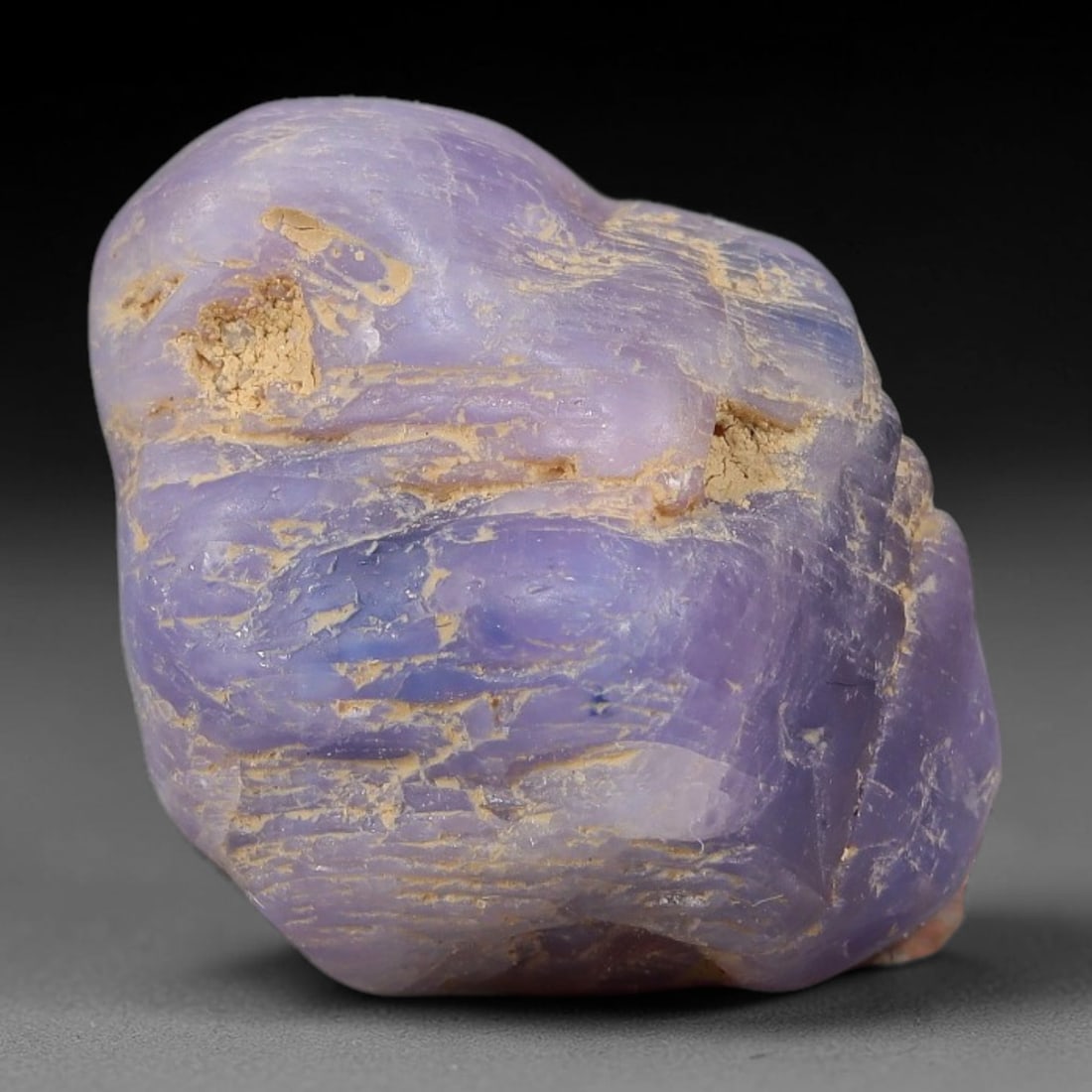 50.70ct Natural Unheated Sri Lankan Purplish Blue Sapphire Rough, 51FC: This natural corundum rough is an unheated purplish blue sapphire sourced from Sri Lankan alluvial gem deposits, featuring an irregular natural native form with residual pale yellow-brown mineral matr