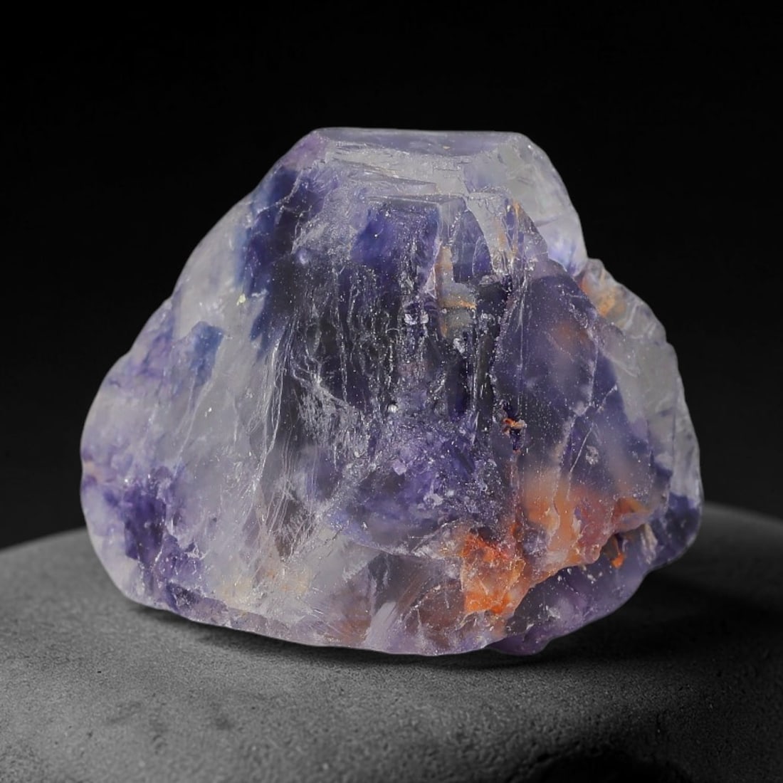 134ct Natural Chinese Deep Violet Purple Fluorite Rough, 9AT: This rugged fluorite rough boasts rich layered violet purple saturation blended with warm rust-colored mineral inclusions that streak its uneven raw surface, soft translucency lets light drift through