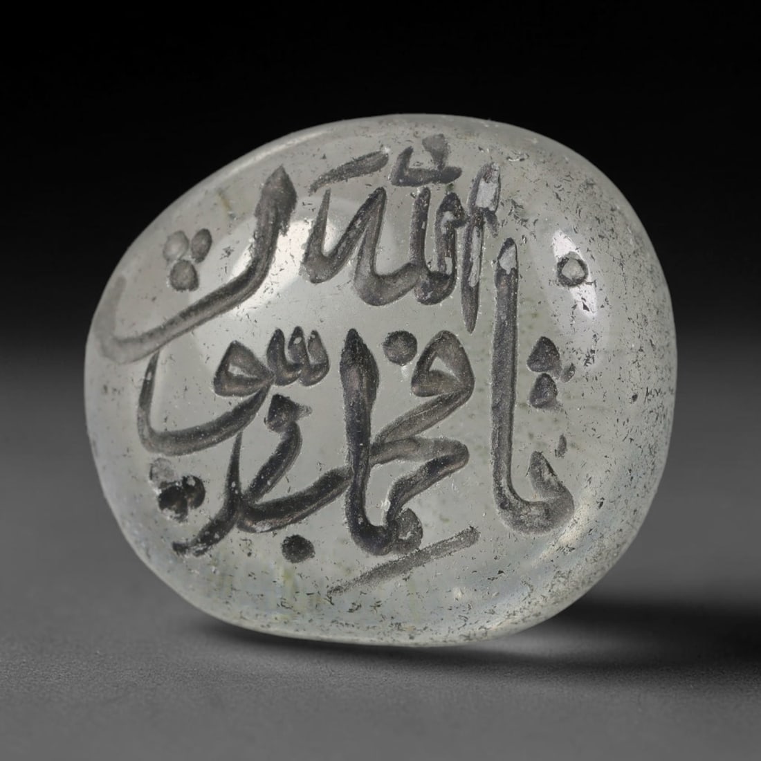 Early Vintage Islamic White Glass Calligraphic Intaglio Seal Cabochon (Post 1900 CE), 78BX: This early vintage glass intaglio seal cabochon draws from enduring Islamic seal-making traditions, formed from translucent pale glass with a smoothly rounded polished surface. The face features caref