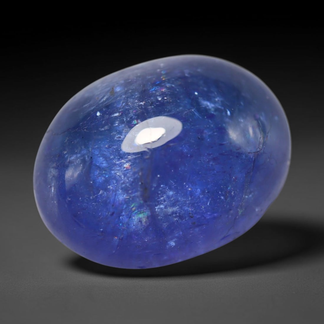 13.02ct Natural Tanzanian Tanzanite Oval Cabochon Loose Gemstone, 67BZ: This smoothly polished oval cabochon is natural tanzanite sourced exclusively from Tanzania, the only known origin for this rare gemstone. It features rich, saturated violet-blue colour across the tra