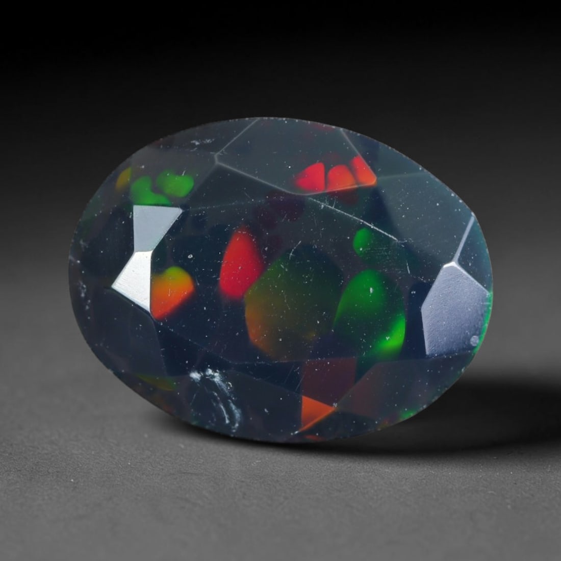 2.07ct Natural Ethiopian Welo Black Smoked Faceted Opal, 12EB: This fully faceted finished opal specimen displays vivid shifting play of color across polished geometric facets within its 11.1x8.6x5.8mm calibrated dimensions, the dark base body amplifies light mov