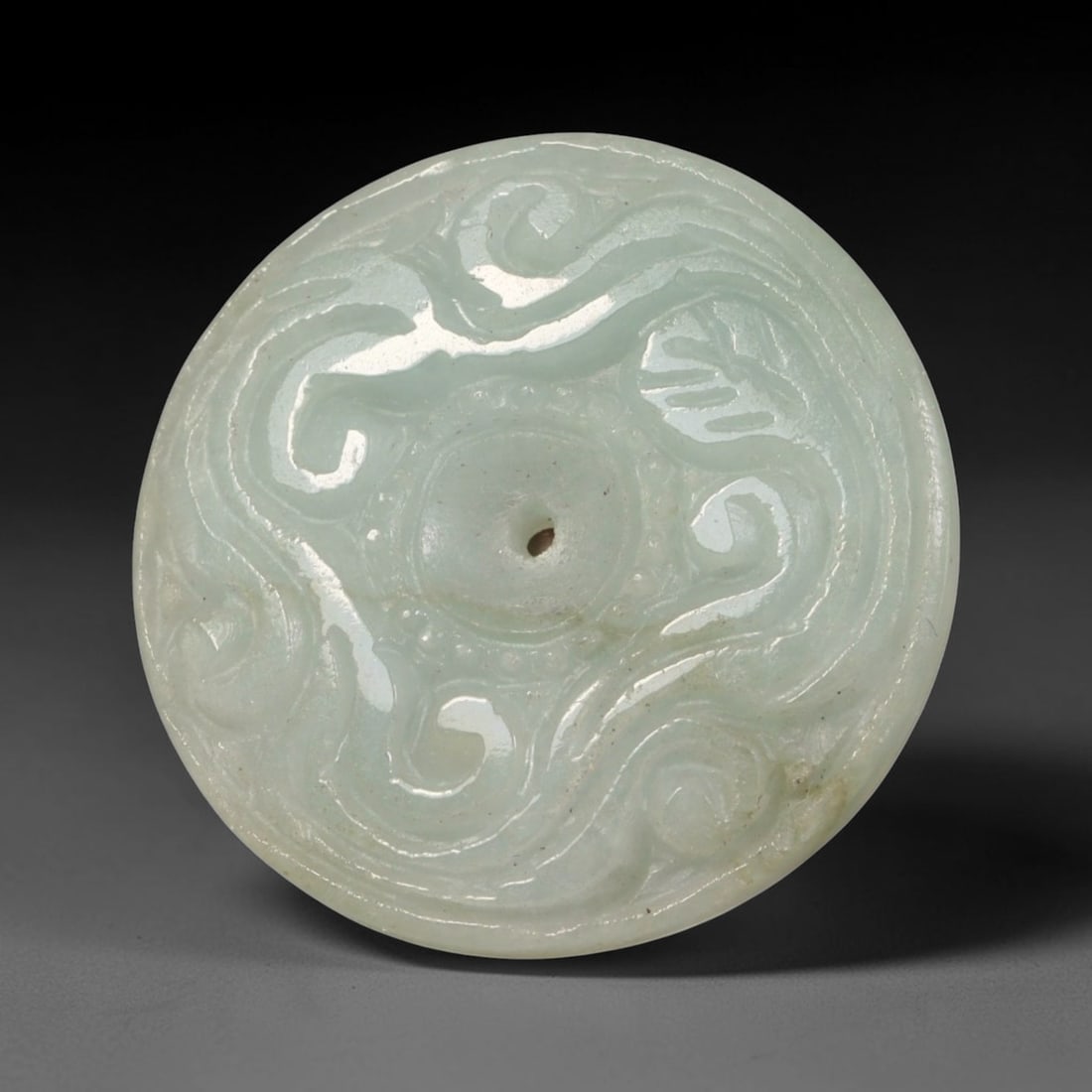 Natural Burmese Type A Jadeite Jade Carved Disc Pendant, 34BP: Artisan hand-carved untreated Burmese Type A jadeite jade circular disc pendant with a 26 mm diameter. The surface is adorned with detailed traditional relief carving finished with a smooth polished s
