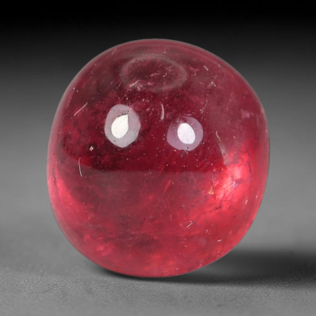 3.54ct Natural Brazilian Rubellite Tourmaline Cabochon Loose Gemstone, 1BC: This smoothly polished cabochon rubellite tourmaline features layered saturated pink-red body saturation with dense natural crystalline mineral flecks and fine internal fracture markings concentrated 