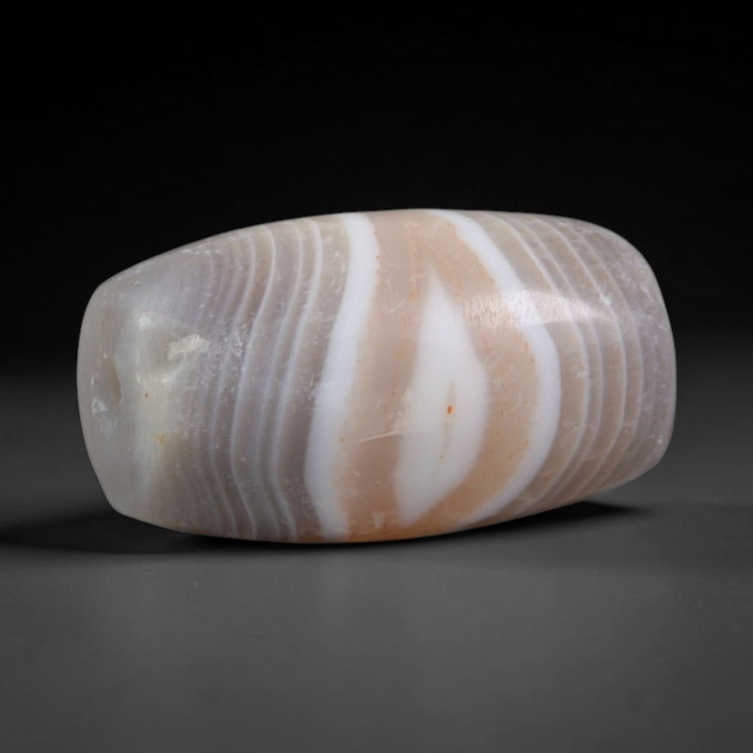 Ancient Parthian Empire Banded Agate Barrel Bead (247 BCE-224 CE), 8AD: This antique banded agate barrel bead originates from the Parthian Empire, a dominant Iranian power that maintained vast Silk Road bead trade networks and refined chalcedony carving for noble talisman