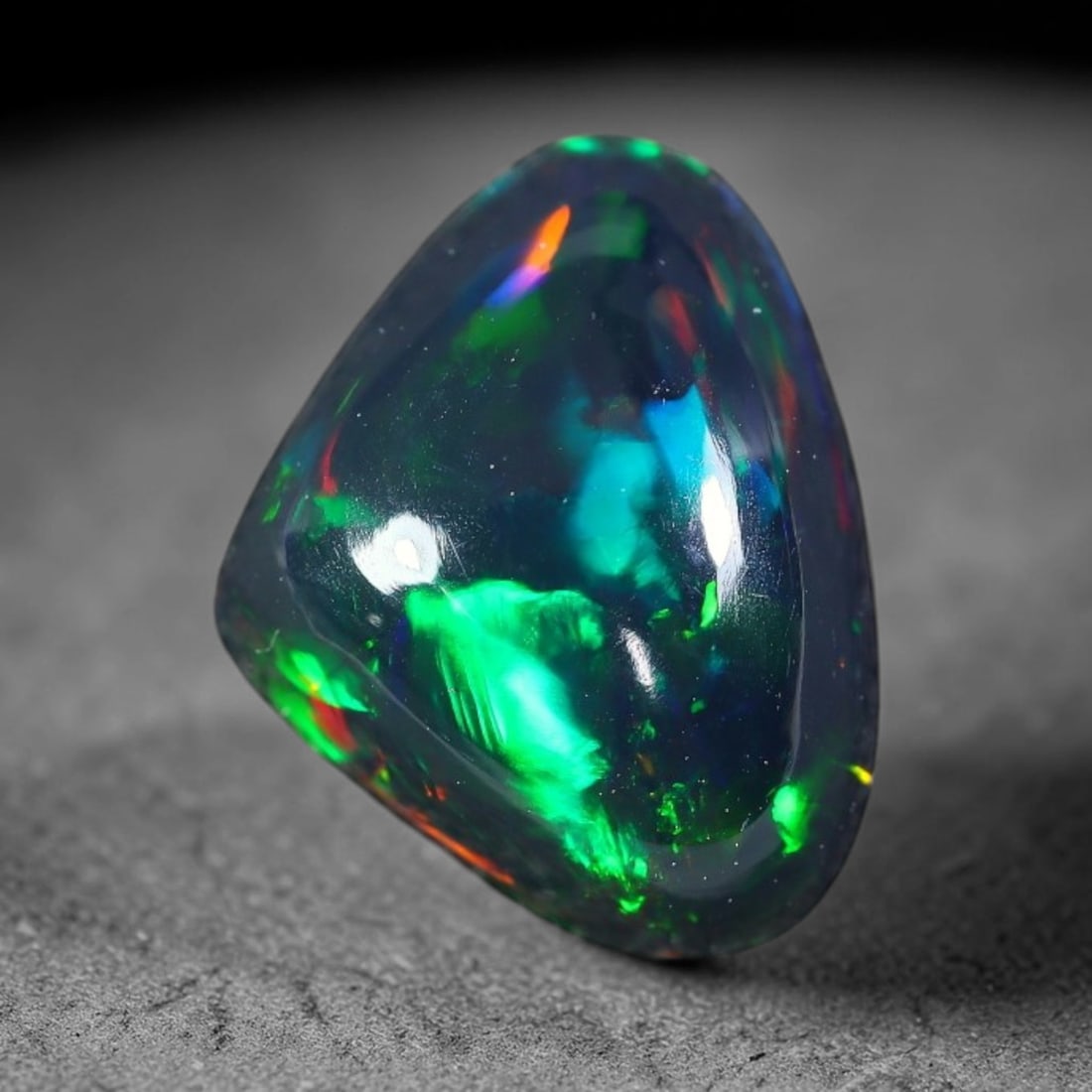 2.65ct Natural Ethiopian Welo Black Smoked Opal Cabochon Loose Gemstone, 25FX: This fully polished Ethiopian Welo opal features a dark smoked base with vivid, sweeping play-of-color shifting across its glossy dome surface, measured at 11x8x6mm. The black smoke treatment deepens 