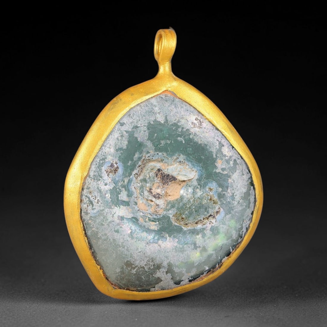 Ancient Roman Glass Slag in Modern Gilt-Edge Pendant, 55FY: This contemporary pendant is crafted from ancient Roman glass slag, featuring a fragmented, iridescent glass surface with weathered patina. The irregular form is bordered by a subtle gilt frame, added