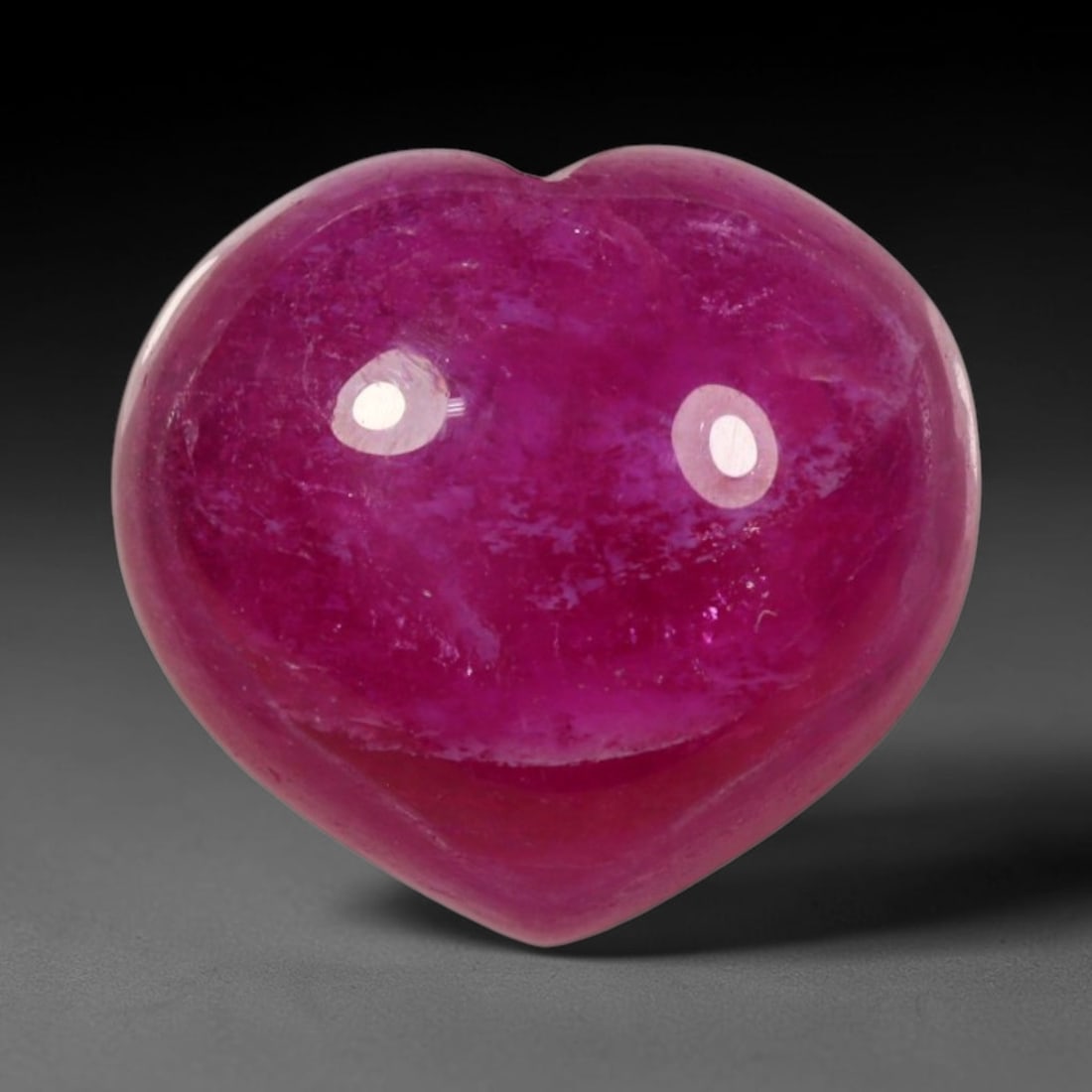 8.34ct Natural Mozambique Hot Pink Ruby Loose Gemstone, 65BP: This heart shaped Mozambique ruby cabochon measures 11.3x10.4x6.3mm, showcasing a vivid saturated hot pink body paired with stunning natural hexagonal crystal growth banding that forms a distinct geom