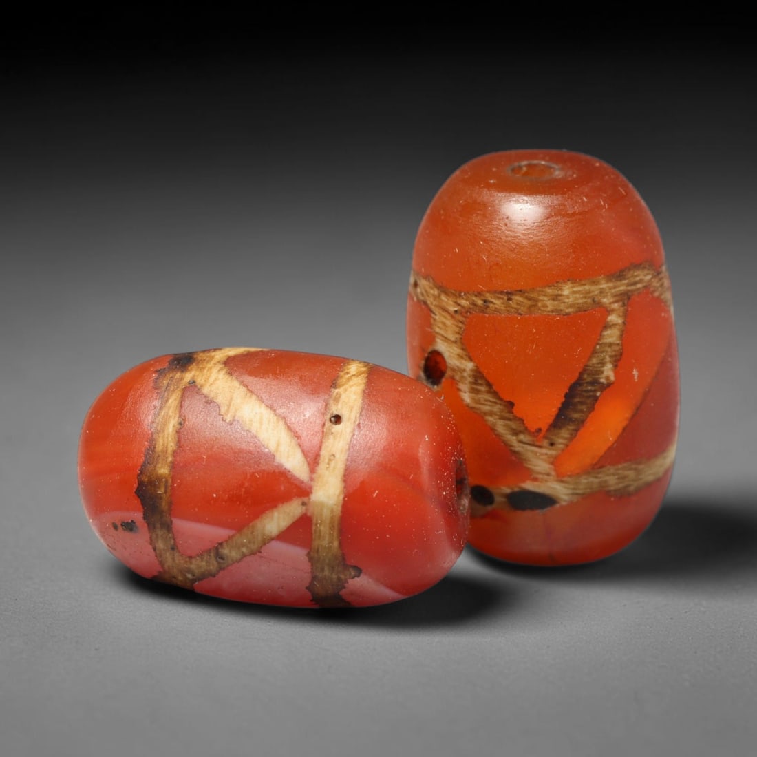 Ancient Medieval Burmese Pagan & Ava Kingdoms Etched Carnelian Barrel Beads (849-1555 CE), 36FY: This pair of antique etched carnelian barrel beads originates from the Medieval Burmese Pagan & Ava Kingdoms, whose etched carnelian bead craft continued to produce trade specimens circulated widely t