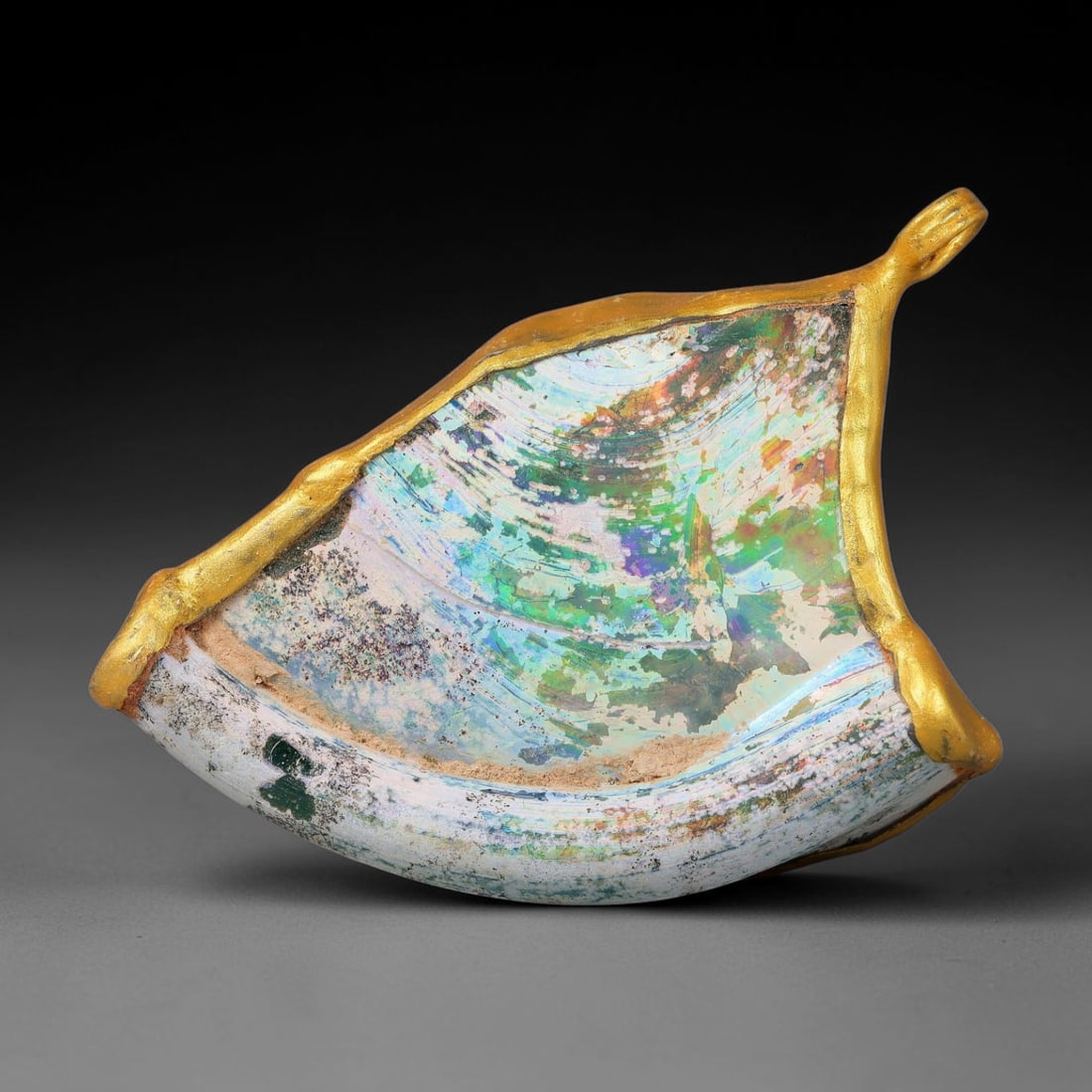 Ancient Roman Glass Slag in Modern Gilt-Edge Pendant, 53FY: This contemporary pendant is crafted from ancient Roman glass slag, featuring a fragmented, iridescent glass surface with weathered patina. The irregular form is bordered by a subtle gilt frame, added