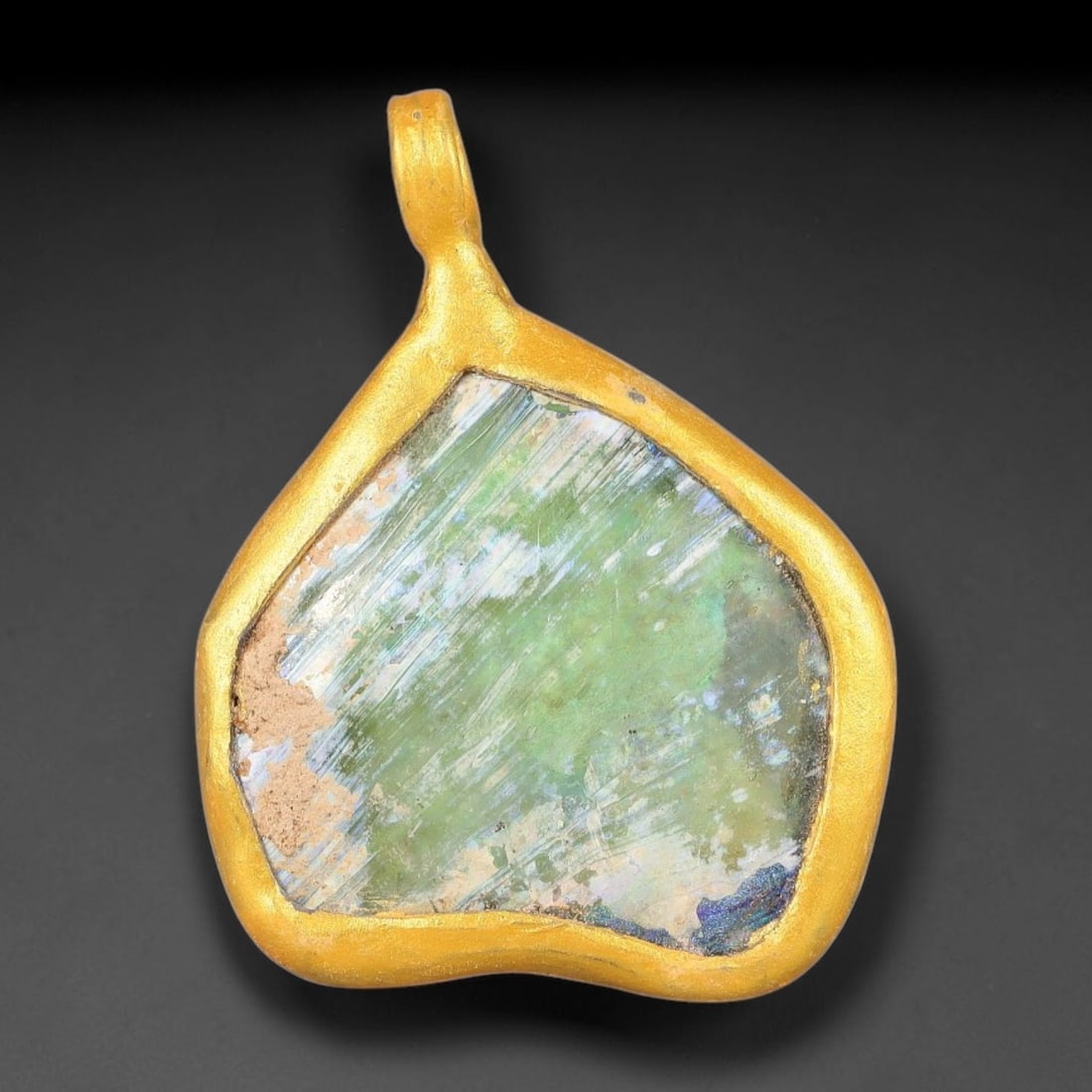 Ancient Roman Glass Slag in Modern Gilt-Edge Pendant, 58FY: This contemporary pendant is crafted from ancient Roman glass slag, featuring a fragmented, iridescent glass surface with weathered patina. The irregular form is bordered by a subtle gilt frame, added
