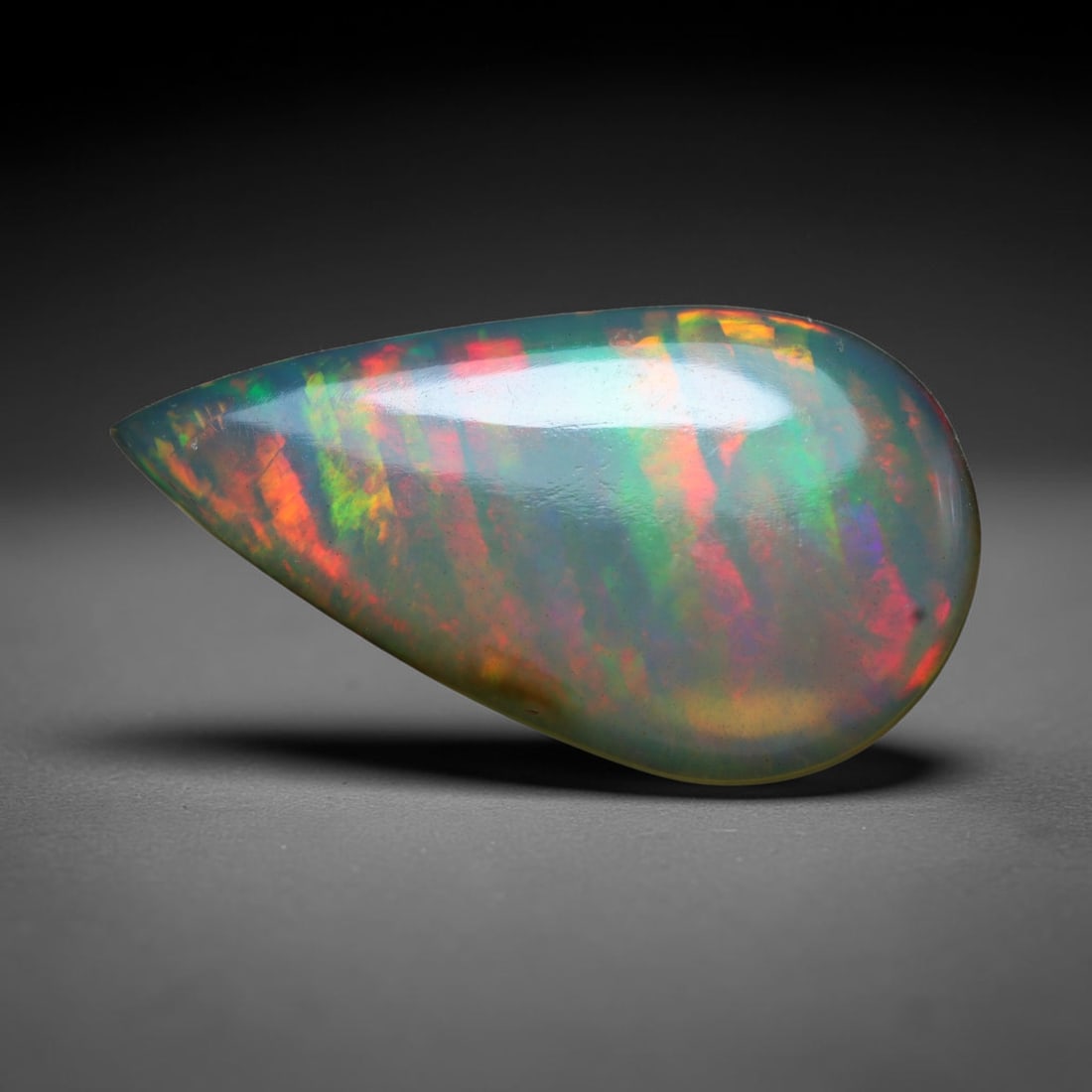 10.06ct Natural Ethiopian Welo Opal Cabochon Loose Gemstone, 59BY: This smoothly polished cabochon is genuine natural Ethiopian Welo opal. The translucent base hosts vivid multi-coloured play-of-colour, displaying dynamic flashes of multi color that shift as the view
