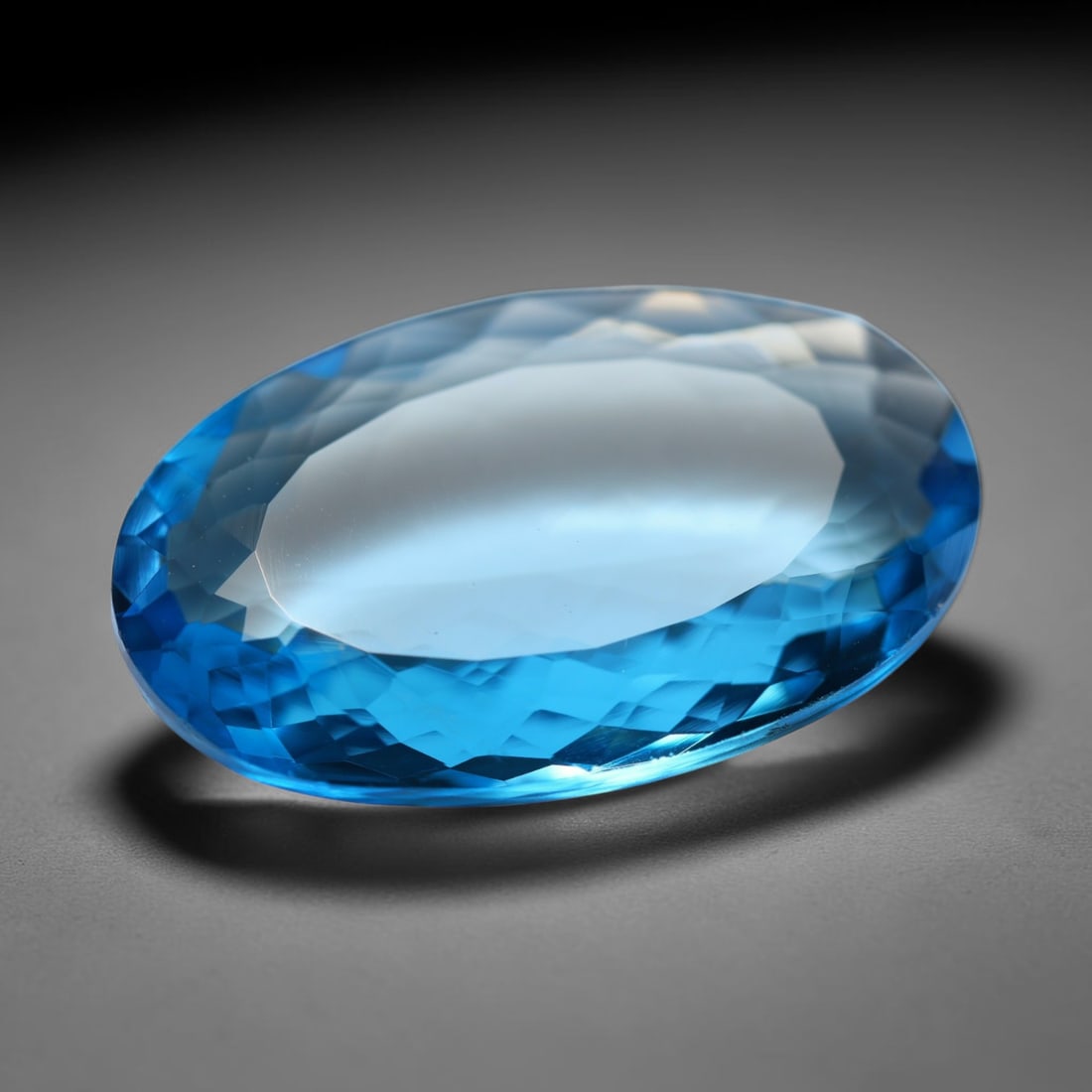 14.45ct Natural Brazilian London Blue Topaz Oval Faceted Loose Gemstone, 91BZ: This precisely cut oval faceted gemstone is natural London Blue Topaz originating from Brazil. The stone showcases an intense, rich deep royal blue hue, complemented by crisp, symmetrical faceting tha