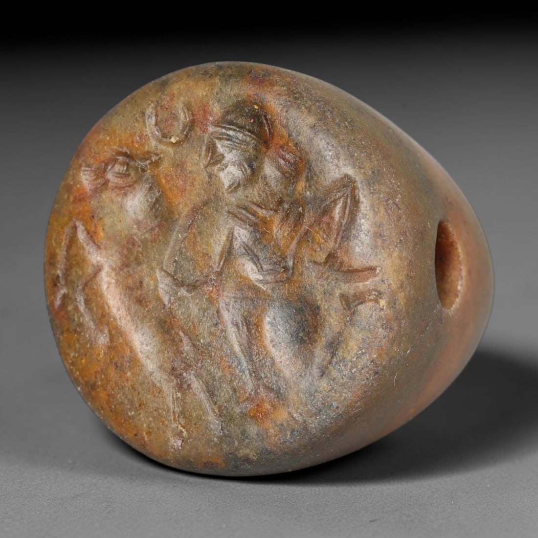 Ancient Sasanian Persian Empire Mottled Brown Stone Conoid Stamp Seal (224-651 CE), 55EC: This mottled brown hardstone conoid stamp seal originates from the Sasanian Persian Empire. Its flat circular face bears an incised intaglio scene depicting a robed figure alongside an animal and luna