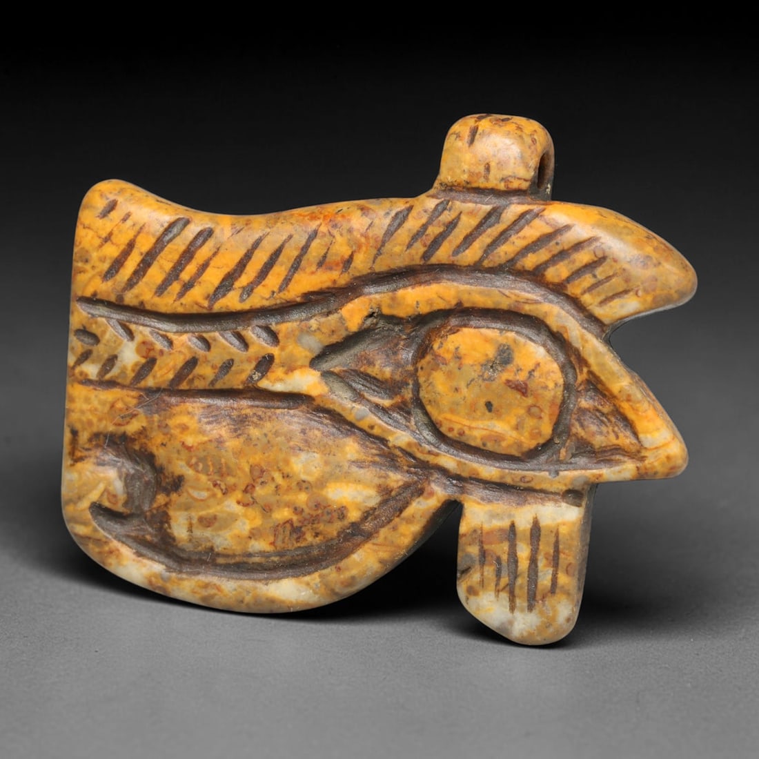 Ancient Predynastic & Pharaonic Egyptian Wedjat Eye Amulet (4000 BCE-30 CE), 2ED: This antique carved stone Wedjat Eye amulet originates from Pharaonic Egyptian civilisation, one of the most iconic protective funerary and personal talismans of ancient Egypt. The meticulously carved