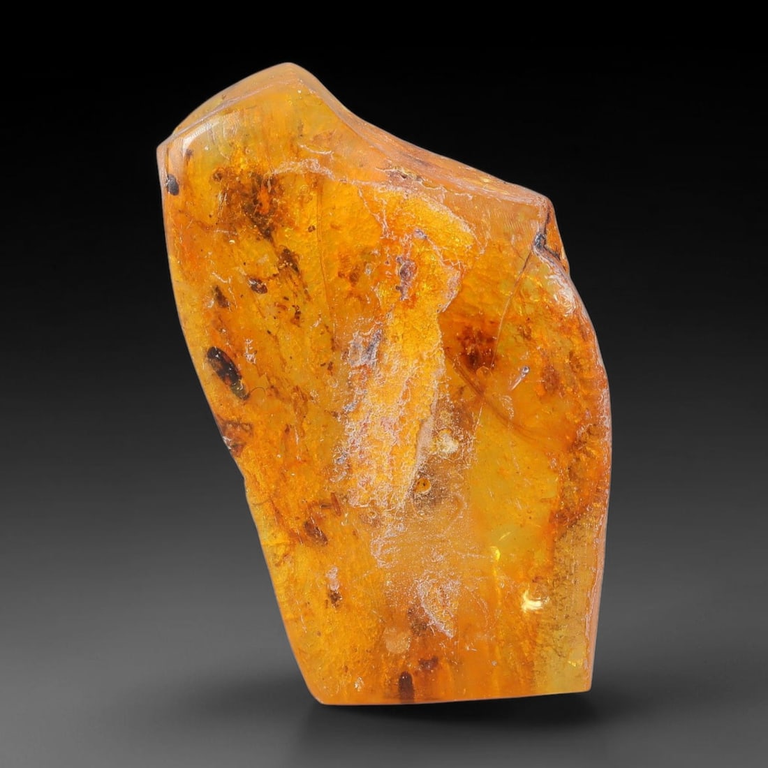 21.91ct Natural Baltic Polished Loose Freeform Amber Gemstone, 56EB: This smoothly polished freeform amber piece carries warm translucent organic clarity with fine natural fossil flecks and tiny mineral inclusions suspended throughout its 34x21mm flowing unstructured s