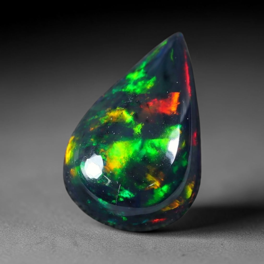 2.65ct Natural Ethiopian Welo Black Smoked Opal Cabochon Loose Gemstone, 77FX: This fully polished Ethiopian Welo opal features a dark smoked base with vivid, sweeping play-of-color shifting across its glossy dome surface, measured at 12x8x5mm. The black smoke treatment deepens 