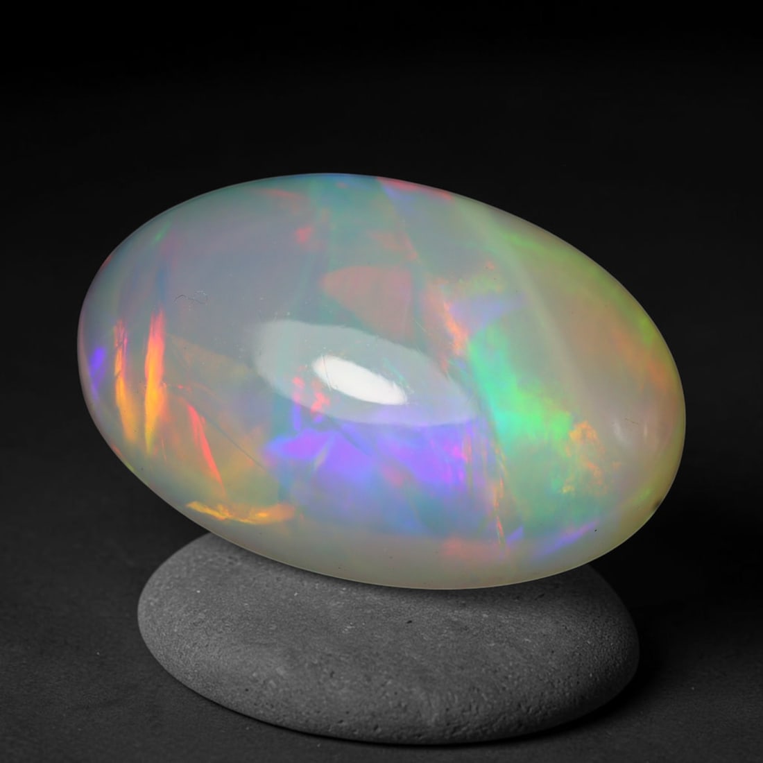 4.92ct Natural Ethiopian Welo Opal Cabochon Loose Gemstone, 27BY: This smoothly polished cabochon is genuine natural Ethiopian Welo opal. The translucent base hosts vivid multi-coloured play-of-colour, displaying dynamic flashes of multi color that shift as the view