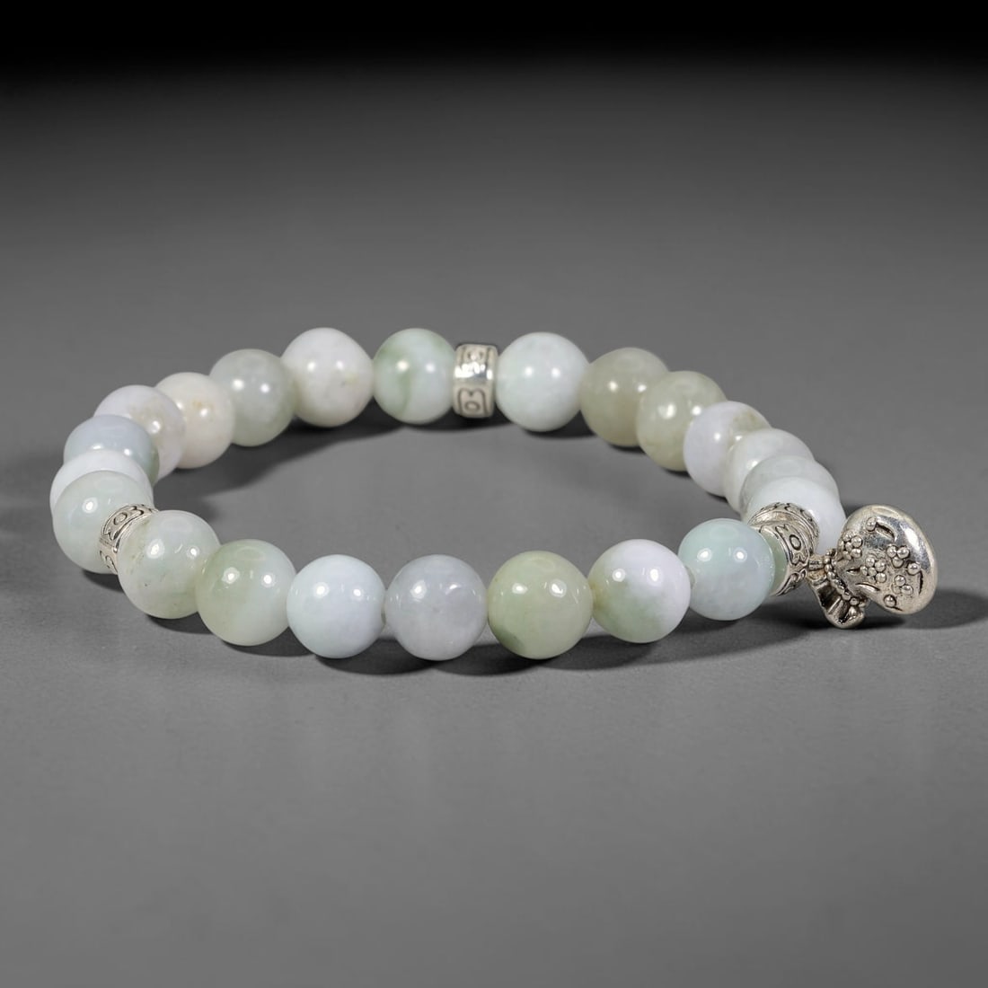 Natural Burmese Type A Jadeite Jade Stretch Bracelet with Antique Silver Charms, 96FV: Comfort elastic stretch bracelet composed of polished natural jadeite beads, fitted with decorative antiqued silver-toned spacers and feature charm. The beads exhibit soft natural tonal variations, st