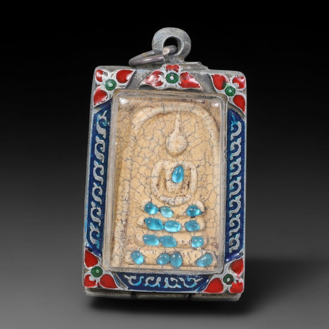 Thai Buddhist Folk Tradition Enclosed Amulet Pendant with Decorative Metal Casing, 44AH: This Thai sacred amulet is housed within an ornate hinged metal protective casing fitted with a top loop for wear as a pendant. The casing features intricate embossed surface detailing and a continuou