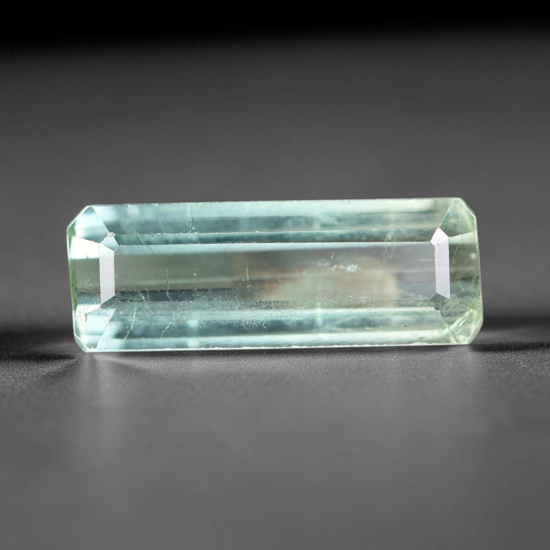 4.00 Carats Natural Mozambique Pale Mint Green Tourmaline Loose Gemstone, 11FM: This natural Mozambique tourmaline boasts dimension measurements of 16x5.7x4mm, displaying a delicate pale mint green hue throughout its fully transparent crystal body, marked with faint natural thin 