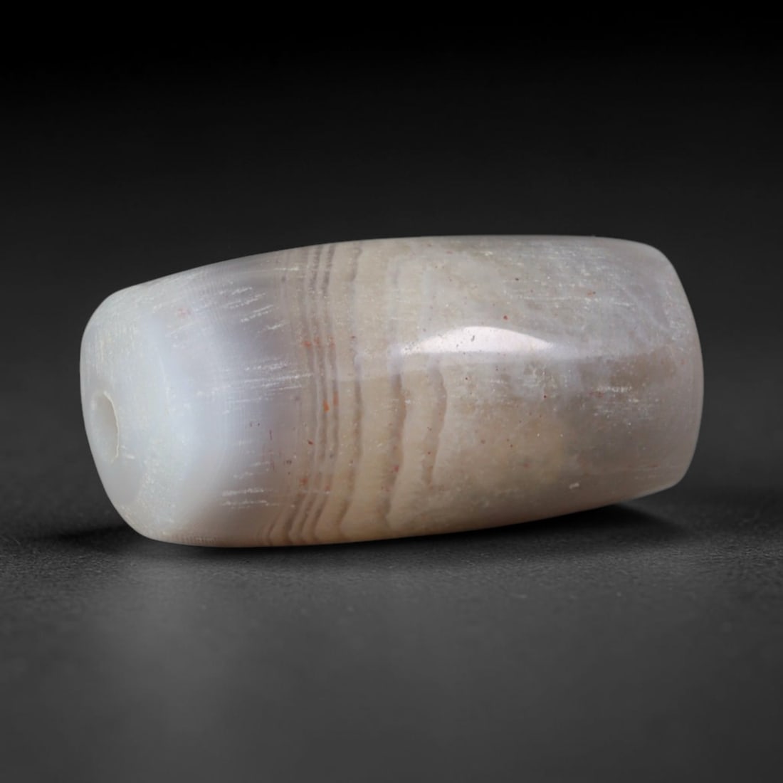 Ancient Han Dynasty Fine Parallel Banded Agate Barrel Bead (202 BCE - 220 CE), 93AD: This antique subtly banded agate barrel bead originates from China's Han Dynasty, a golden age of ancient Chinese lapidary arts that saw widespread production of polished stone ornaments for elite dai
