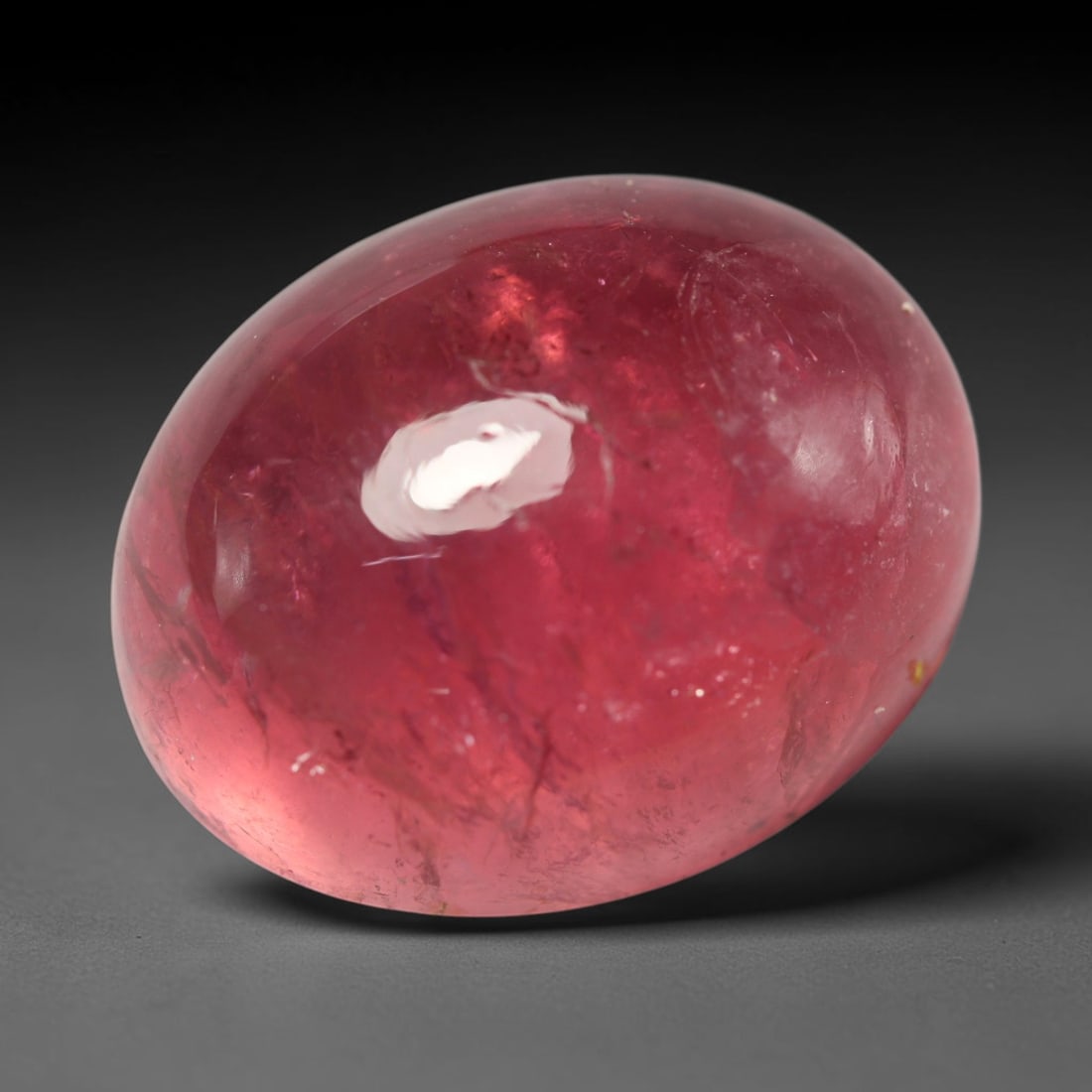 35.85ct Natural Mozambican Rubellite Tourmaline Oval Cabochon Loose Gemstone, 78BZ: This smoothly polished oval cabochon is natural rubellite tourmaline originating from Mozambique. It exhibits a lush saturated pinkish-red hue distributed throughout the translucent crystal matrix, wi