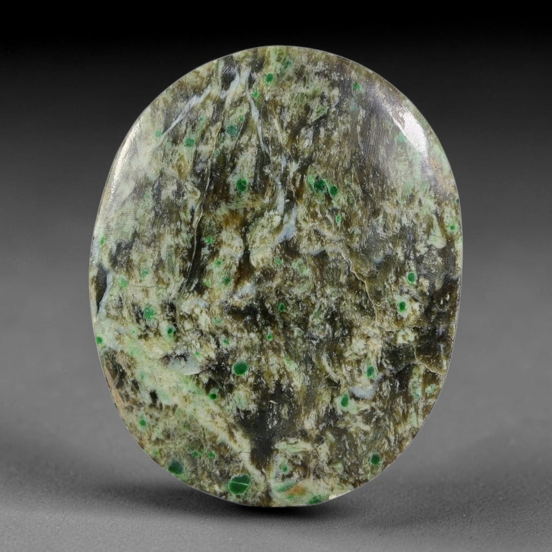 12.53ct Natural Burmese Type A Green Dot Scenic Matrix Jadeite Jade Cabochon, 37FA: This single untreated natural Burmese Type A oval jadeite jade cabochon measures 25x20.3x3.5mm with a total weight of 12.53ct. The stone features an earthy brownish-grey scenic host matrix dotted with