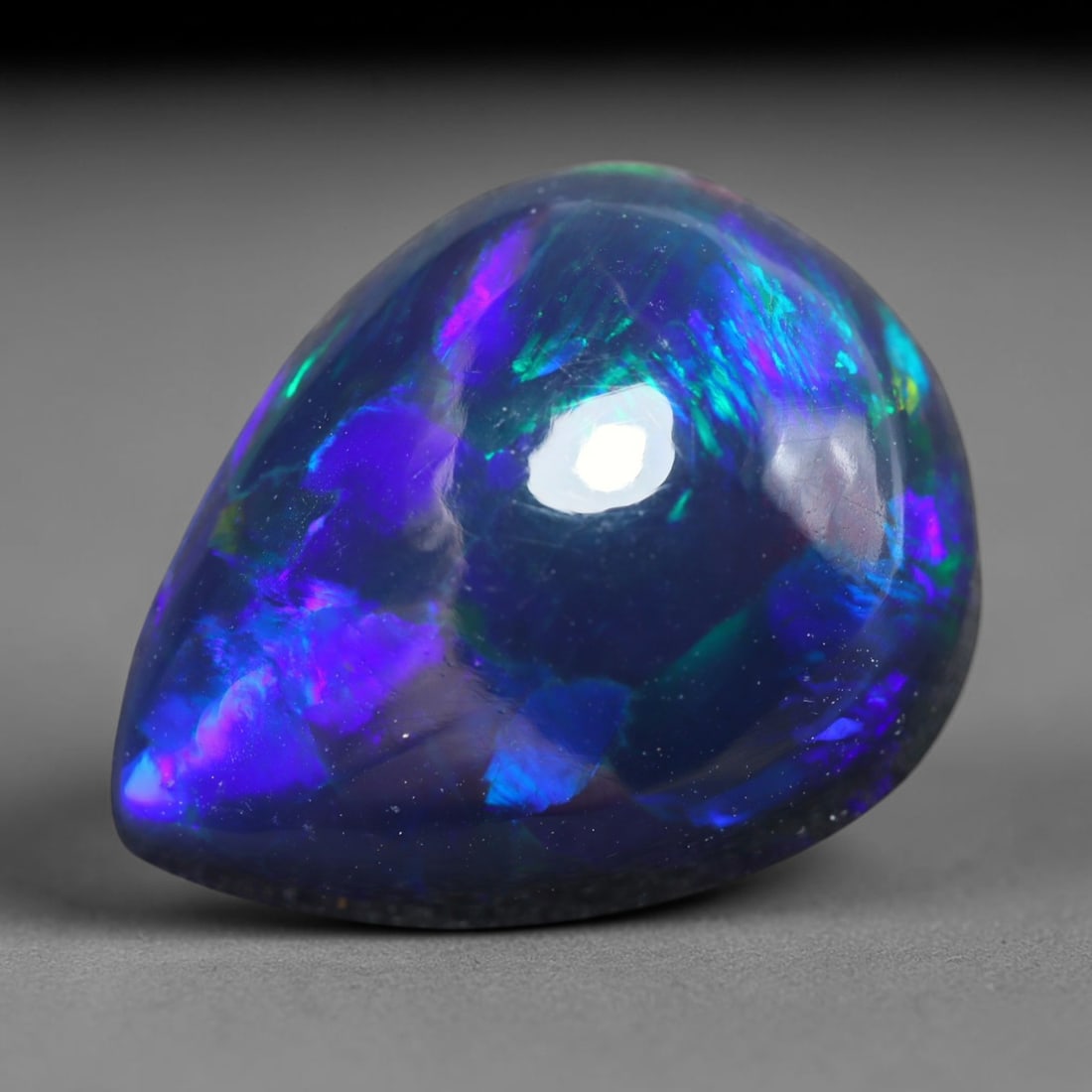 6.19ct Natural Ethiopian Welo Black Smoked Opal Cabochon Loose Gemstone, 14BY: This fully polished Ethiopian Welo opal features a dark smoked base with vivid, sweeping play-of-color shifting across its glossy dome surface, measured at 15x12x8mm. The black smoke treatment deepens
