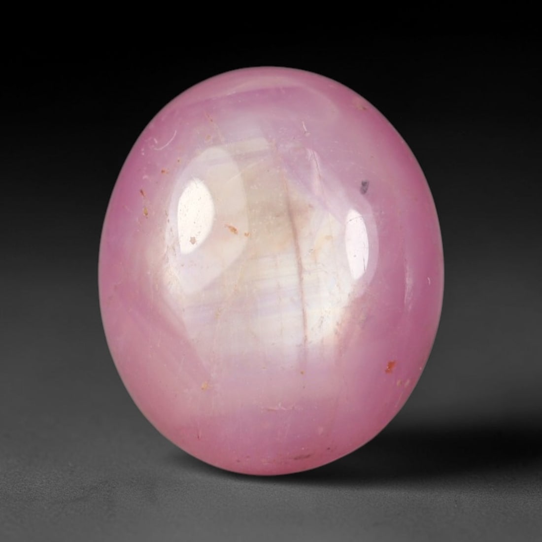 4.03ct Natural Mozambican Soft Bubblegum Pink Ruby Cabochon Loose Gemstone, 51BD: This smoothly polished domed ruby cabochon displays a gentle soft bubblegum pink body tone with faint natural linear mineral veining and tiny scattered rust-hued mineral flecks embedded within its tra