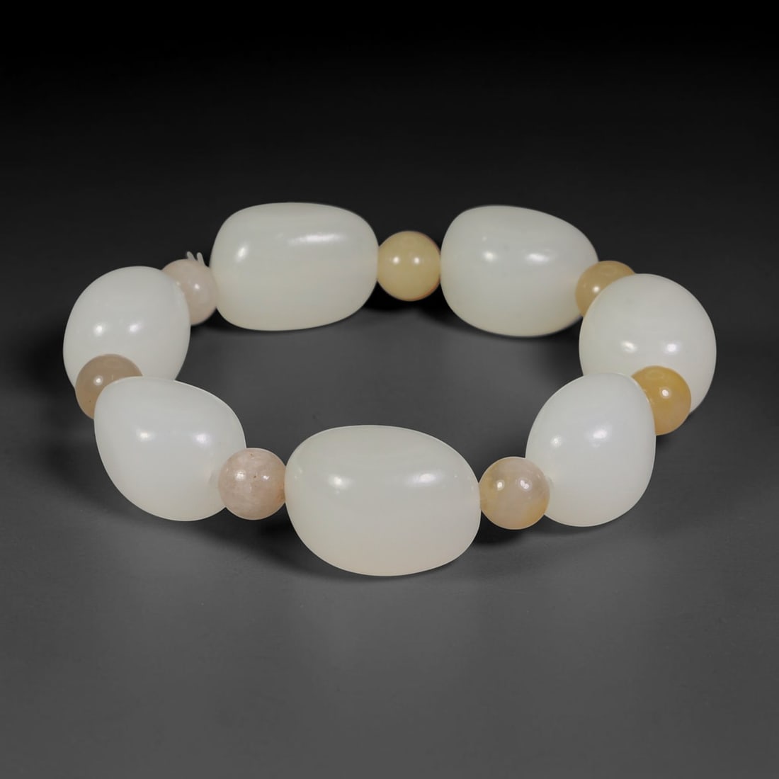 Natural Chinese White Jade Beaded Bracelet - Freeform Jade Pale Stone Spacer Strand, 4AP: Hand-strung bracelet crafted with smooth freeform natural Chinese white jade beads measuring 17mm, separated by small round pale yellow and beige mineral stone spacer beads to accentuate the soft milk