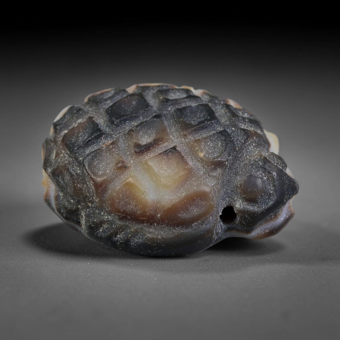 Ancient Medieval Mughal Indian Culture Banded Agate Carved Amulet (1526-1857 CE), 39EC: This antique carved banded agate amulet originates from Mughal Indian craft traditions. Banded chalcedony stones were widely worked into wearable protective talismans and personal ornaments across Sou