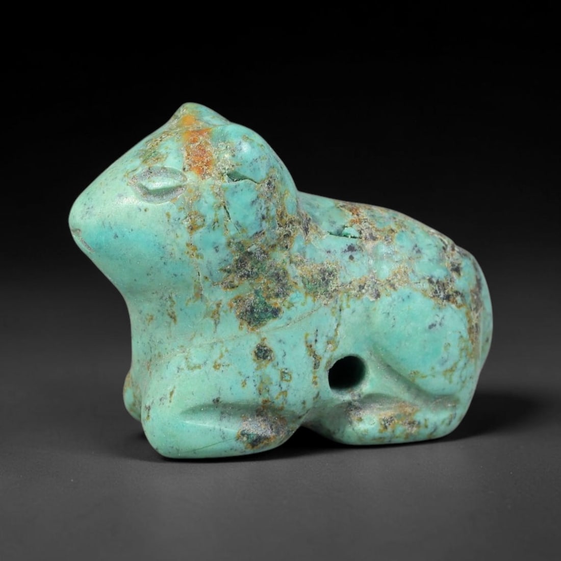 Ancient Sasanian Persian Turquoise Feline Amulet Bead (224-651 CE), 14EC: This antique recumbent feline amulet bead carved from natural turquoise originates from the Sasanian Persian Empire. Zoomorphic feline charms were revered as symbols of guardianship, courage and spiri