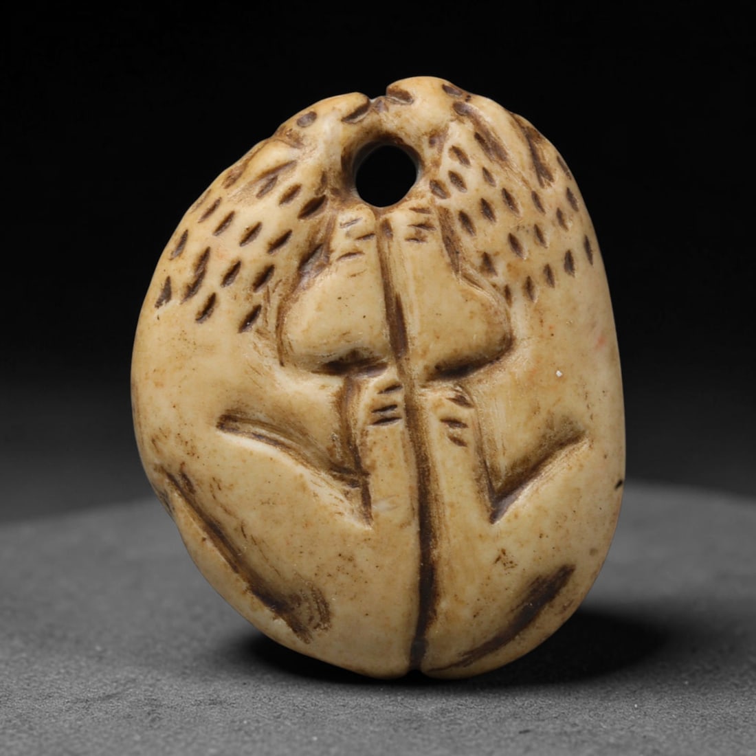 Ancient Sasanian Persian Carved Bone Zoomorphic Pendant (224-651 CE), 60ED: This antique carved bone pendant originates from the Sasanian Persian Empire, crafted as a wearable talisman for personal adornment in late antiquity. The plaque features a deeply carved paired zoomor