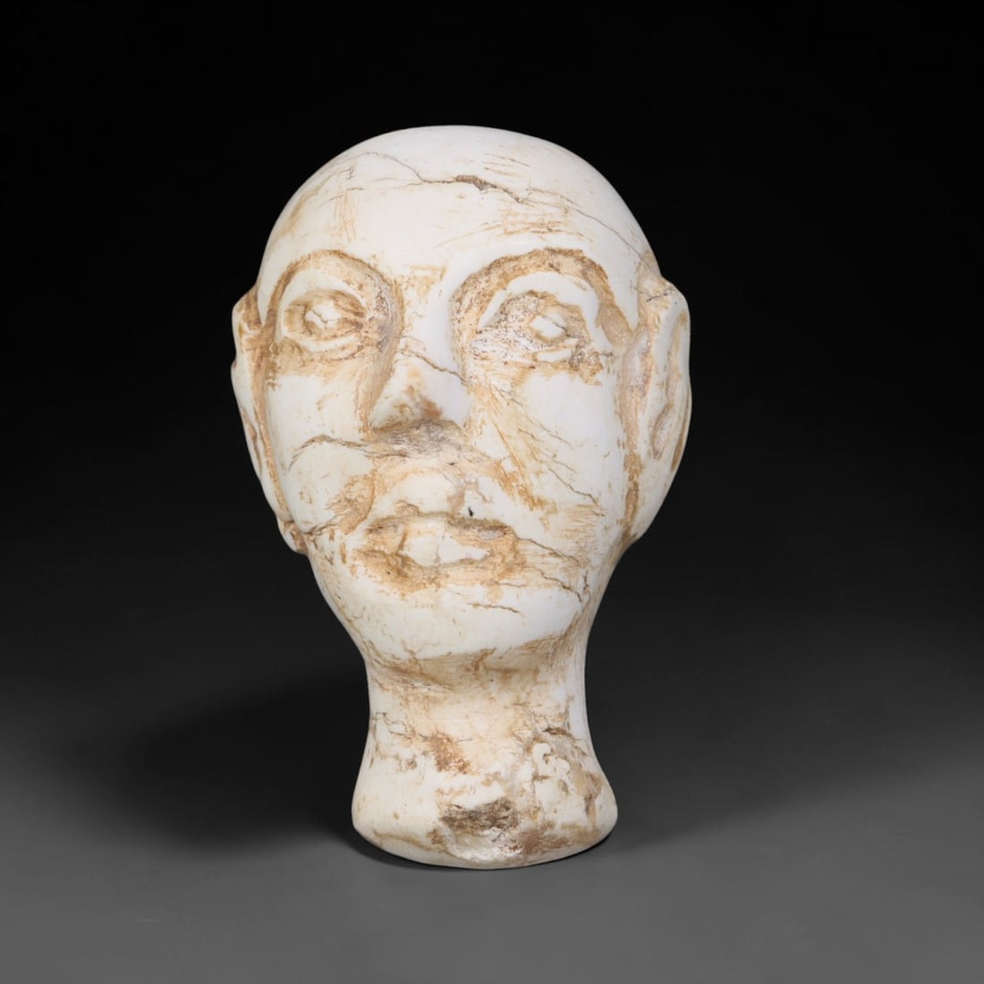 Ancient Bactrian White Stone Human Head Bust (c.200 BCE-200 CE), 10EF: This pale carved stone human head originates from Ancient Bactrian culture. The bald head features clearly defined carved facial features including inset-style eyes, prominent nose and distinct lip de
