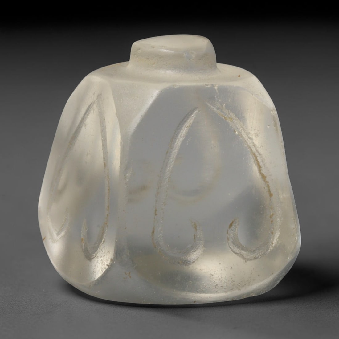 Ancient Medieval Mamluk Engraved Clear Glass Talisman Bead (1250-1517 CE), 64ED: This antique faceted glass talisman bead originates from the Mamluk cultural sphere, crafted for personal adornment and protective talismanic wear. The translucent pale glass body features deeply engr