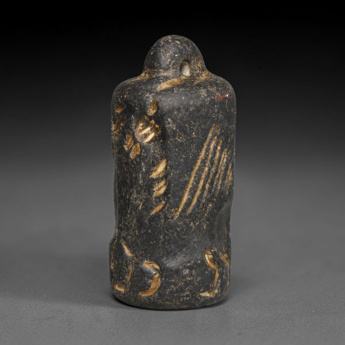 Ancient Sasanian Persian Dark Stone Cylinder Seal (c.224-651 CE), 9ED: This dark stone cylinder seal originates from Ancient Sasanian Persian culture. The cylindrical body is adorned with incised figural and linear decorative motifs. A perforated knob at the apex enables