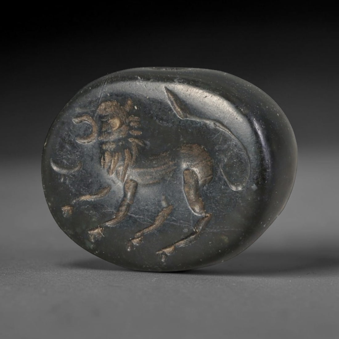 Ancient Sasanian Persian Conoid Stamp Seal (c.224-651 CE), 89ED: This dark polished stone conoid stamp seal originates from Ancient Sasanian Persian culture. The oval sealing face bears finely incised figural imagery carved in characteristic Sasanian stylistic conv