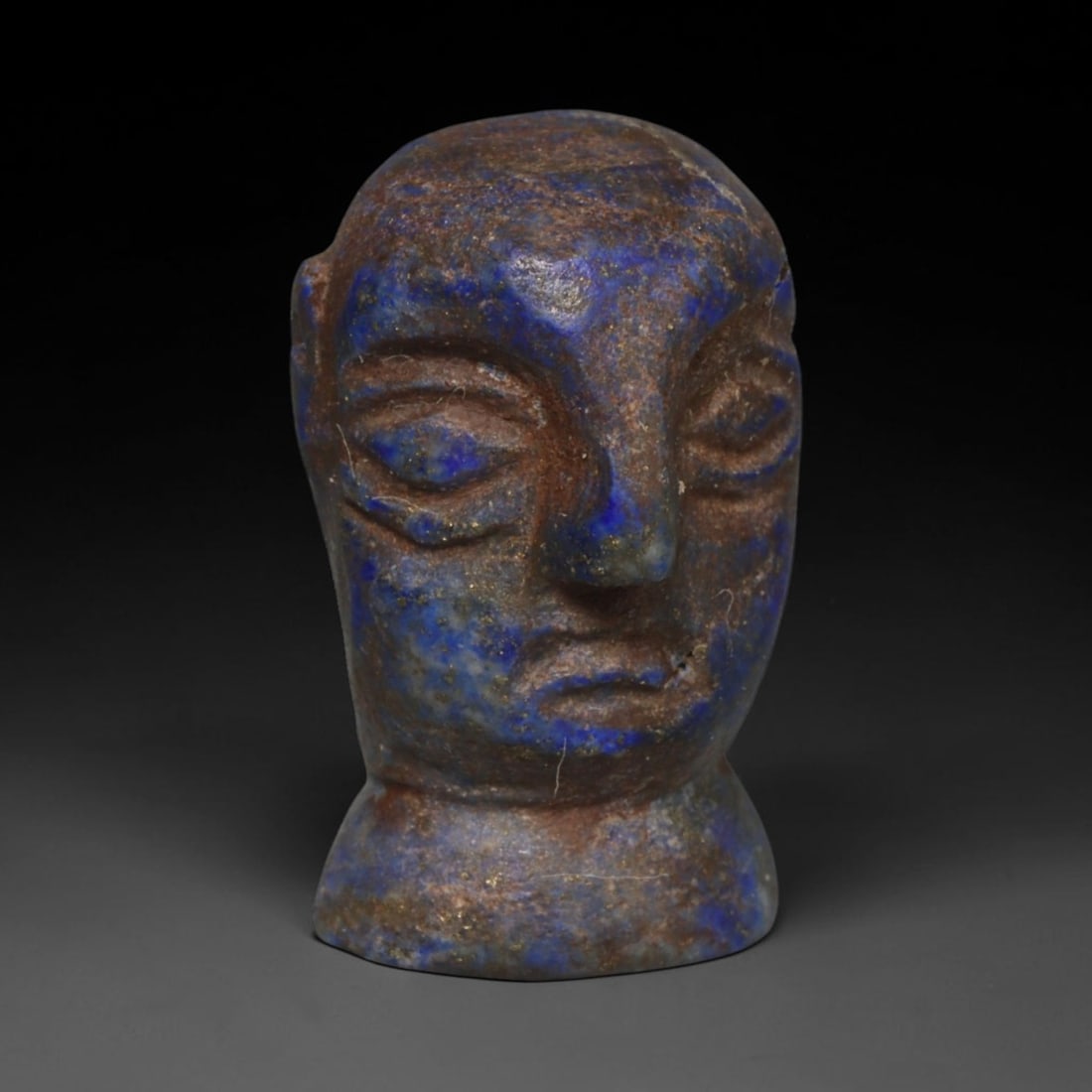 Ancient Bactrian Lapis Lazuli Idol Head (250 BCE-200 CE), 18ED: This carved lapis lazuli idol head originates from Greco-Bactrian Culture, a historic Silk Road civilization blending Hellenistic and Central Asian artistic traditions. Softly modelled facial features