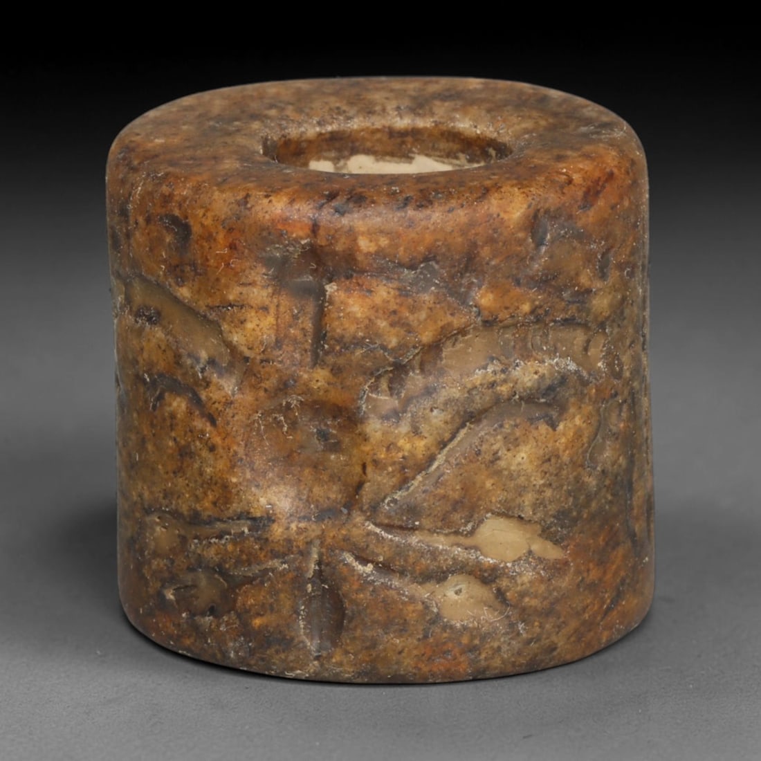 Ancient Sasanian Persian Carved Stone Cylindrical Talisman Bead (224-651 CE), 74ED: This antique cylindrical perforated stone talisman bead originates from the Sasanian Persian Empire, crafted as a wearable protective amulet during late antiquity. The exterior surface bears worn carv