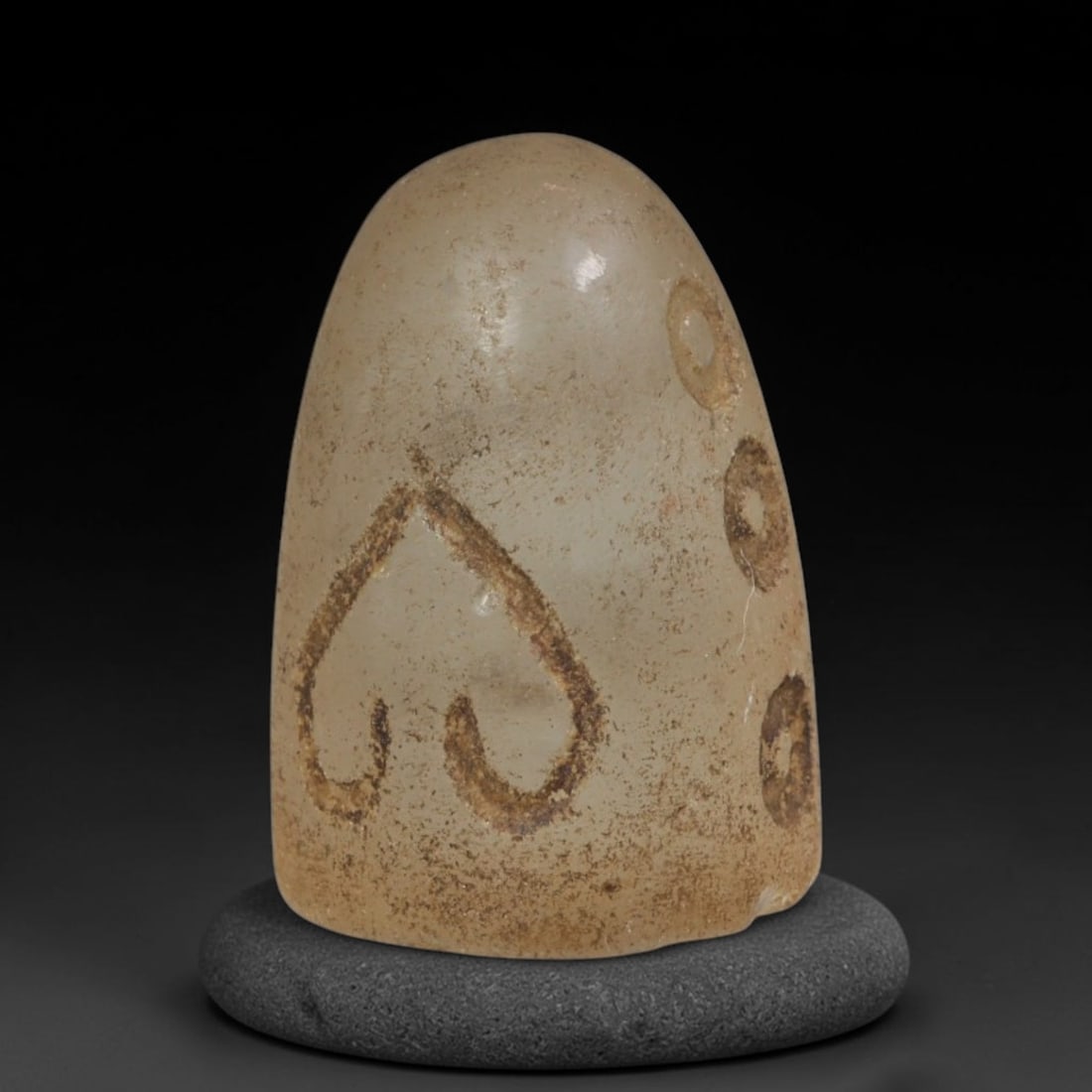 Ancient Mamluk Rock Crystal Talisman Amulet (c.1250-1517 CE), 90ED: This translucent rock crystal conical talisman originates from the Mamluk era. Its surface bears incised symbolic motifs including a heart-shaped emblem and circular ring symbols, filled with ancient 