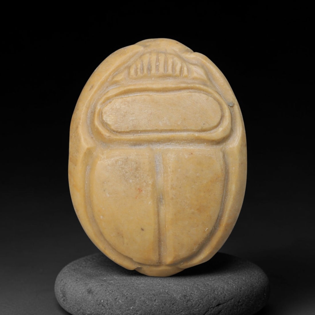 Ancient Near Eastern Yellow Stone Scarab Stamp Seal, 55EF: This pale yellow stone scarab-form stamp seal originates from the Ancient Near Eastern sphere. The obverse is modelled in classic scarab beetle form with defined carapace segmentation. The flat base c