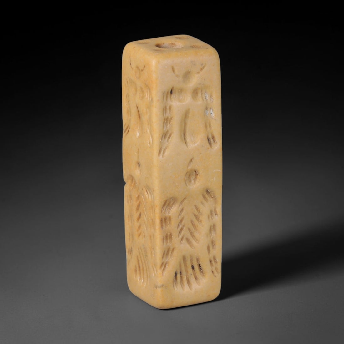 Ancient Mesopotamian Rectangular Cylinder Seal (c.2300-539 BCE), 58EF: This pale stone rectangular cylinder seal originates from Ancient Mesopotamia. All four vertical faces feature carefully incised ancient figural motifs executed in traditional Mesopotamian carving sty